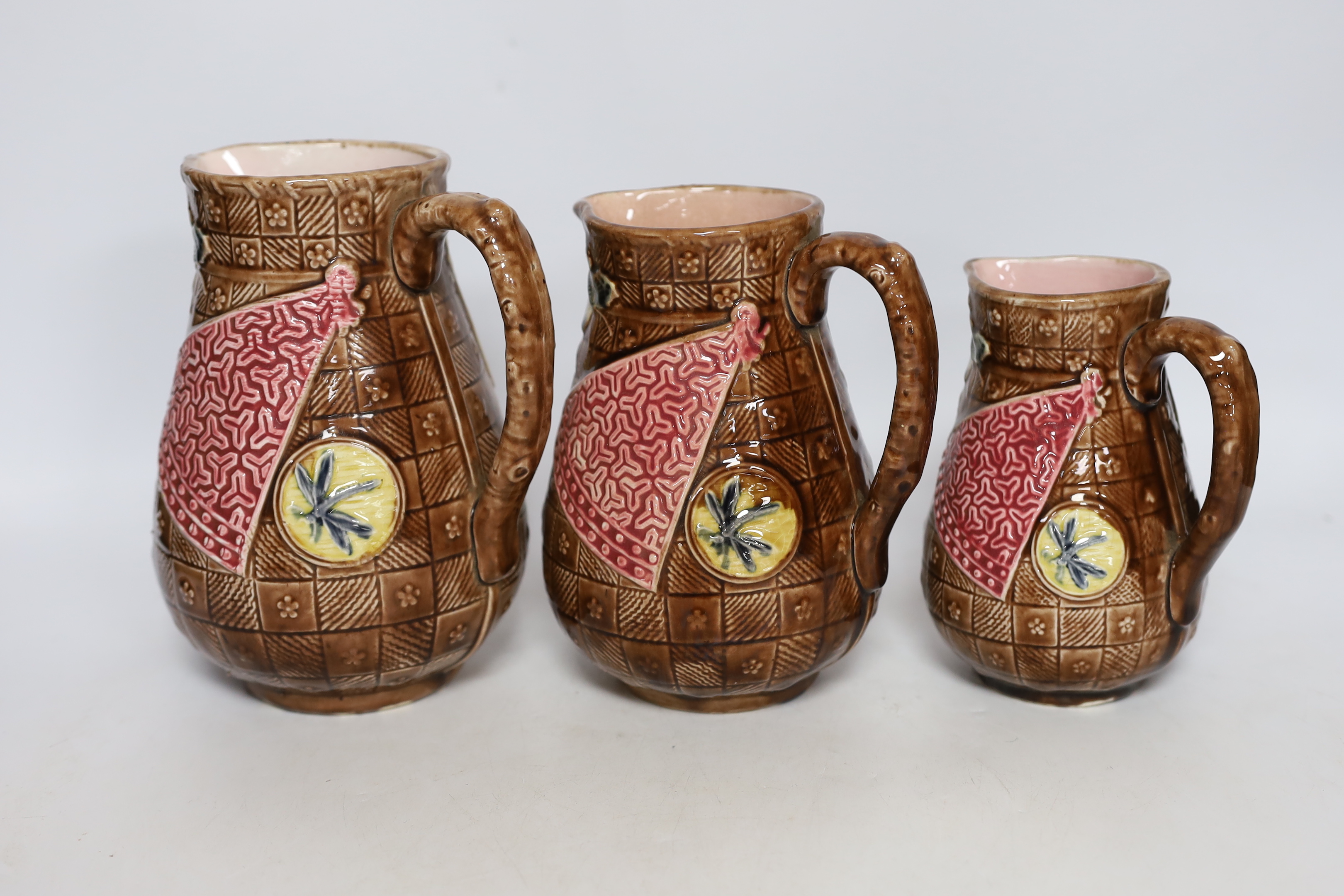 A set of three Aesthetic period graduated majolica jugs, tallest 19.5cm